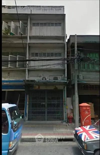 Urban street view of a three-story commercial building with potential for renovation.