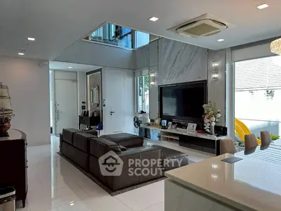 Luxurious modern living room with sleek design and large TV, perfect for entertaining.