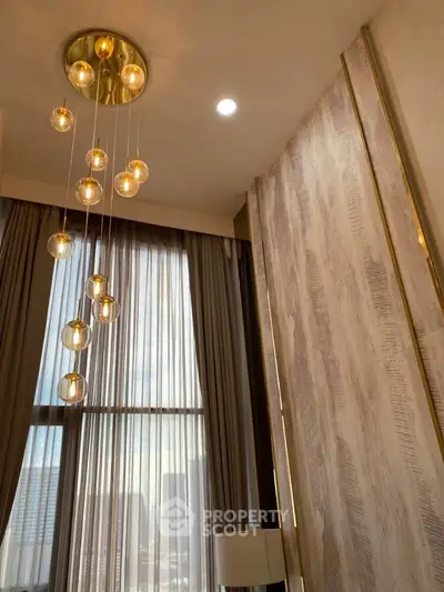 Luxurious high-ceiling living room with elegant lighting and floor-to-ceiling windows.