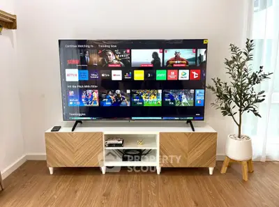 Modern living room with sleek TV unit and large flat-screen TV, perfect for entertainment enthusiasts.