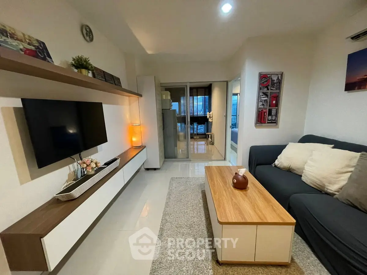 Modern living room with sleek furniture and cozy ambiance, featuring a wall-mounted TV and stylish decor.