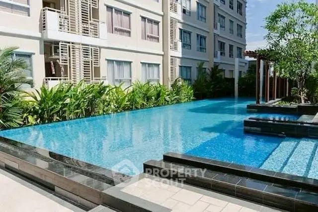Luxurious apartment complex with stunning outdoor pool and lush greenery.