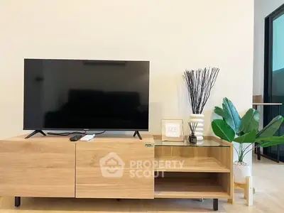 Modern living room with sleek TV stand and indoor plants for a cozy ambiance.