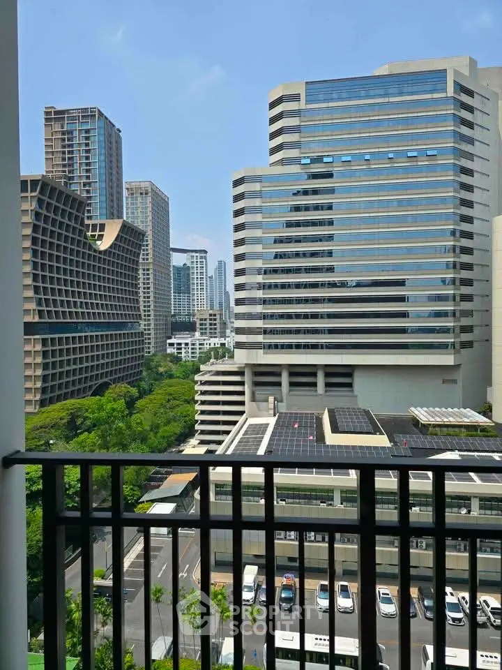 Stunning cityscape view from a high-rise balcony overlooking modern skyscrapers and lush greenery.