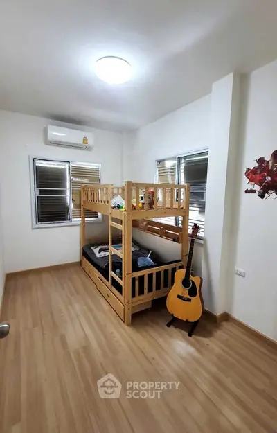 Cozy bedroom with bunk bed and guitar, perfect for kids or guests.