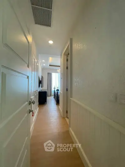 Bright hallway leading to a cozy living room with elegant decor and natural light.