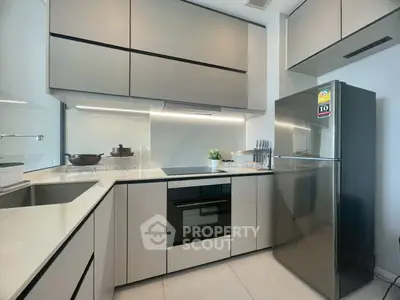 Modern kitchen with sleek cabinetry and stainless steel appliances in a contemporary apartment.