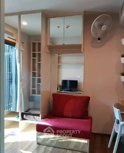 Cozy living room with modern furniture and wall-mounted fan in a compact apartment setting.