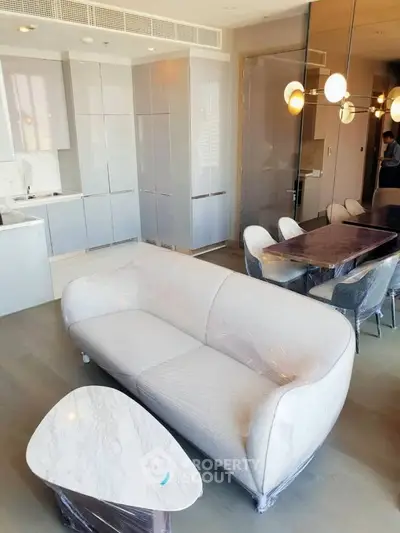 Modern open-layout living room with stylish furniture and dining area in a contemporary apartment.