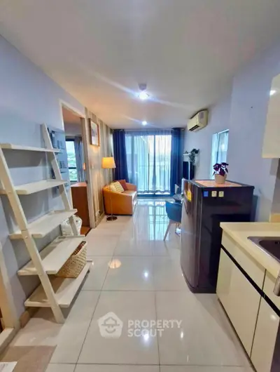 Modern open-plan living room with sleek kitchen and bright natural light.