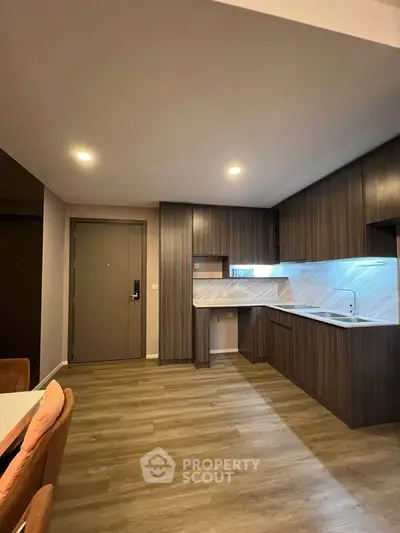 Modern kitchen with sleek cabinetry and wood flooring in a stylish apartment.
