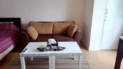 Cozy living room with a stylish sofa and modern coffee table in a well-lit apartment.
