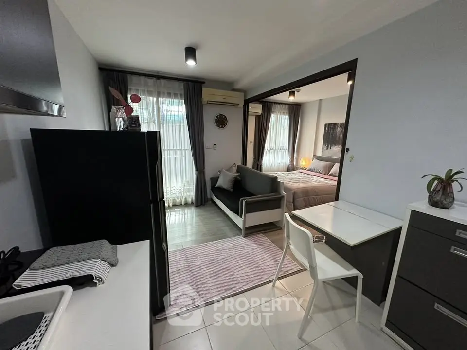 Modern open-plan apartment with sleek kitchen and cozy living area, perfect for urban living.