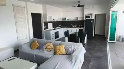 Modern open-layout living room and kitchen with sleek design and cozy seating area.