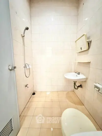 Compact bathroom with shower, sink, and toilet in minimalist design.