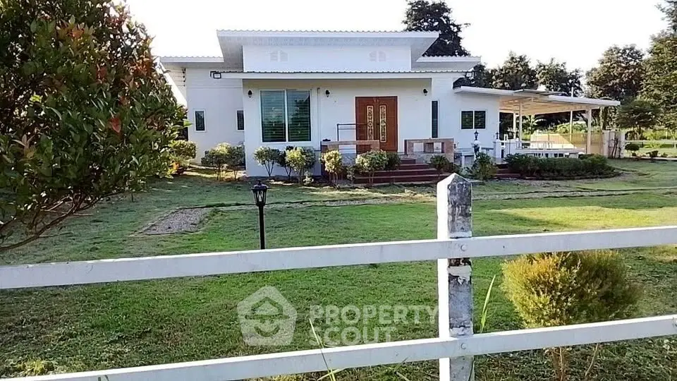 Charming single-story white house with lush green lawn and modern design.