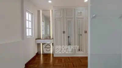 Elegant bathroom with mirrored cabinets and wooden flooring