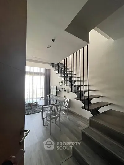 Modern duplex interior with stylish staircase and cozy dining area