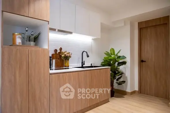Modern kitchen with sleek wooden cabinets and stylish black faucet, perfect for contemporary living.