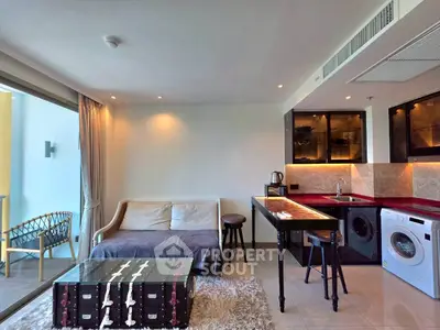 Modern living room with open kitchen, stylish furniture, and balcony access in a contemporary apartment.