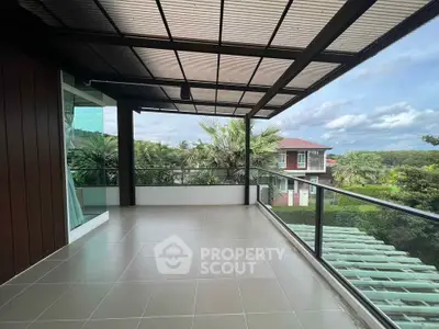 Spacious balcony with scenic view of lush greenery and modern architecture.