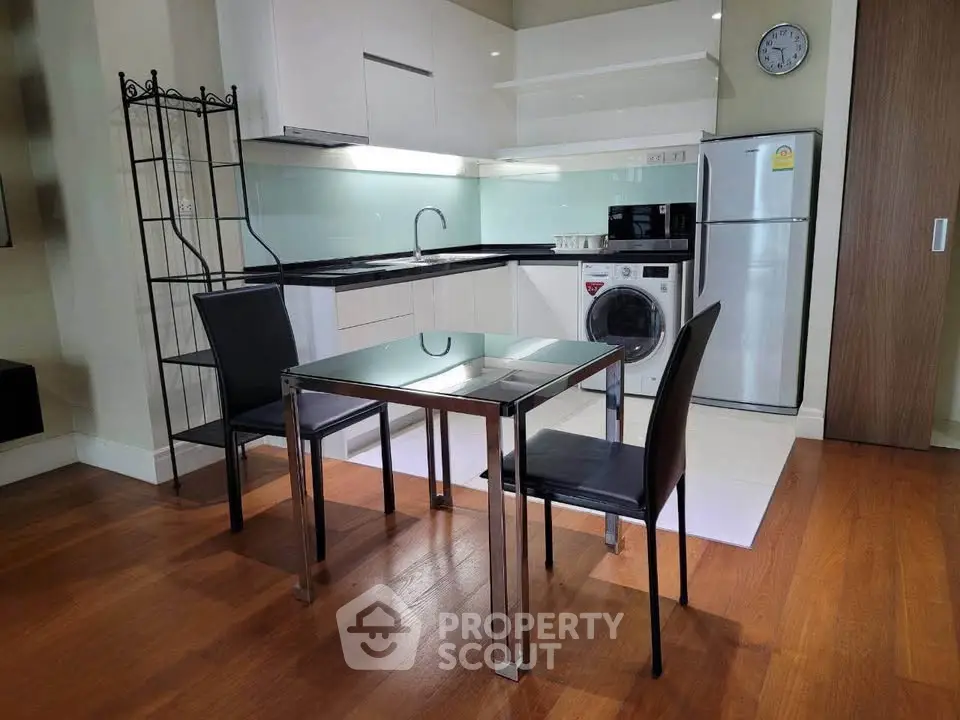 Modern kitchen with sleek appliances and dining area in stylish apartment