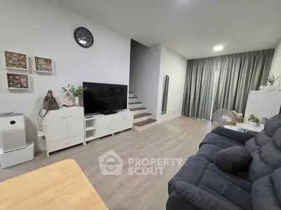 Modern living room with stylish decor, cozy seating, and sleek entertainment setup.
