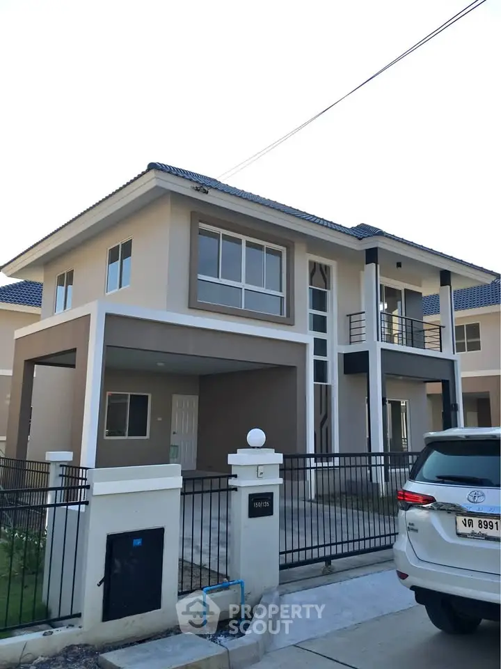 Modern two-story house with spacious driveway and sleek design in a suburban neighborhood.
