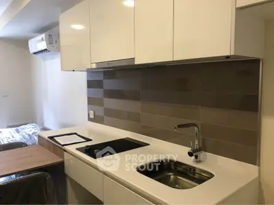 Modern kitchen with sleek cabinetry and induction cooktop in a stylish apartment.