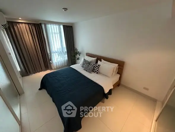 Modern bedroom with stylish decor and natural light in a cozy apartment.