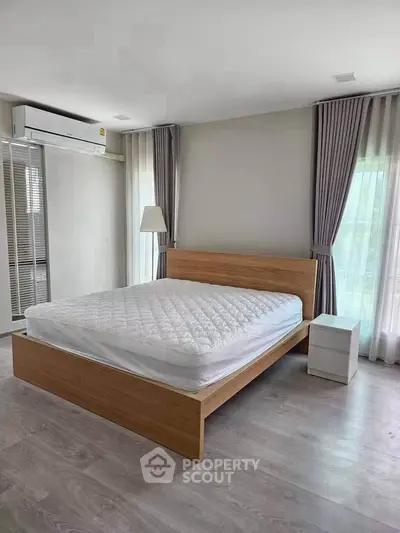 Spacious bedroom with modern wooden bed and natural light