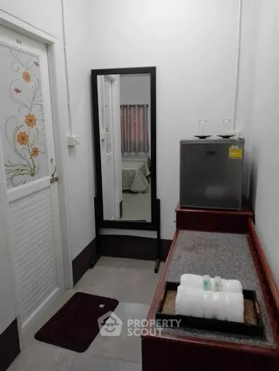 Cozy interior with mini fridge and mirror, ideal for compact living spaces.