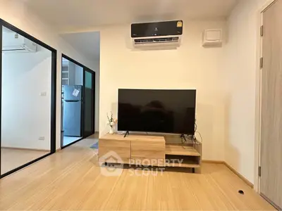 Modern living room with sleek TV setup and air conditioning in a cozy apartment.