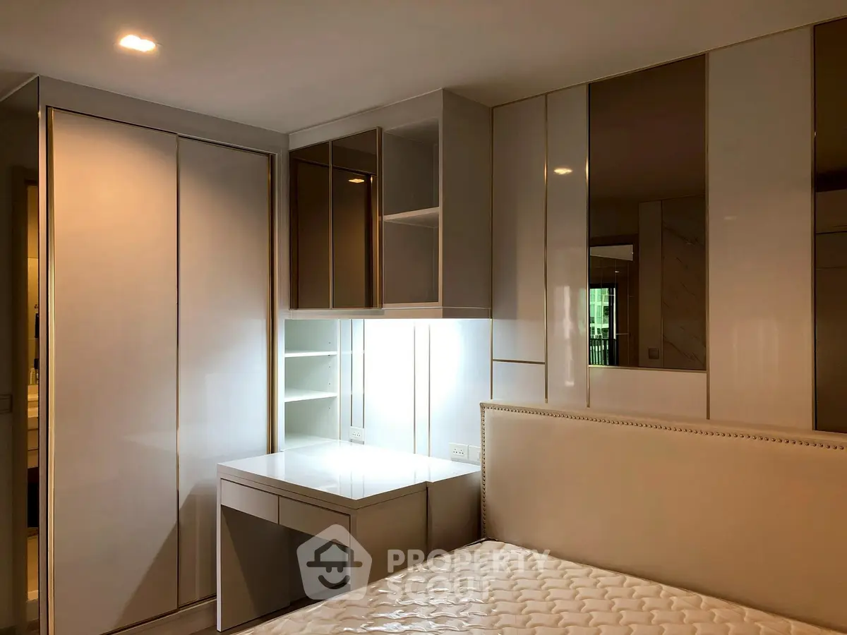 Modern bedroom with built-in wardrobe and study desk, featuring sleek design and ample storage.