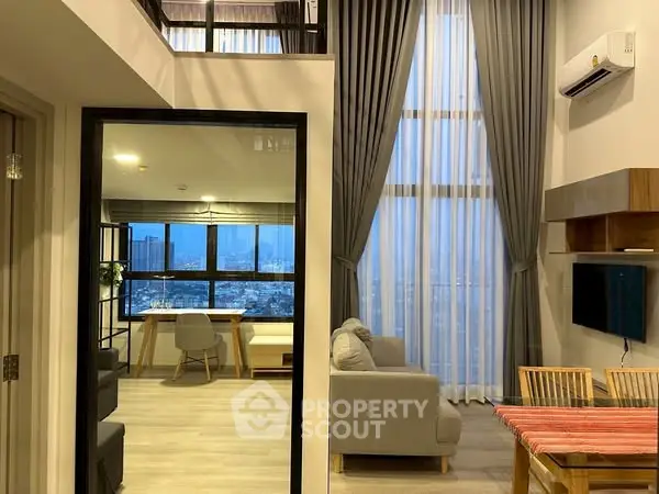Modern living room with high ceilings and city view, featuring elegant decor and spacious layout.