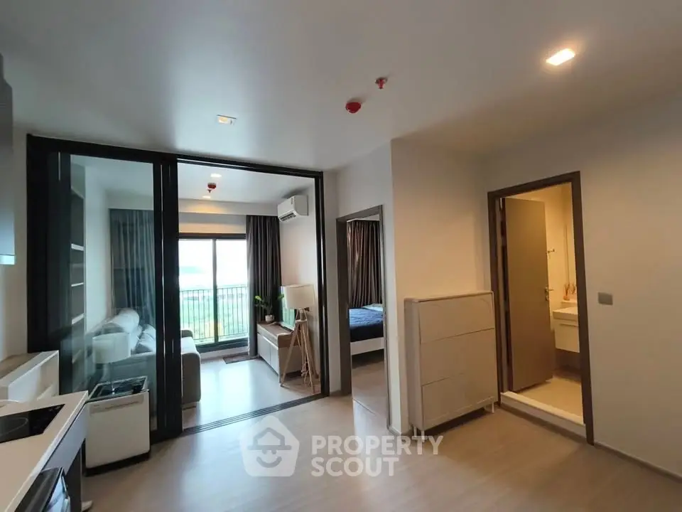 Modern apartment interior with open layout, featuring a cozy living room, bedroom, and kitchen area.