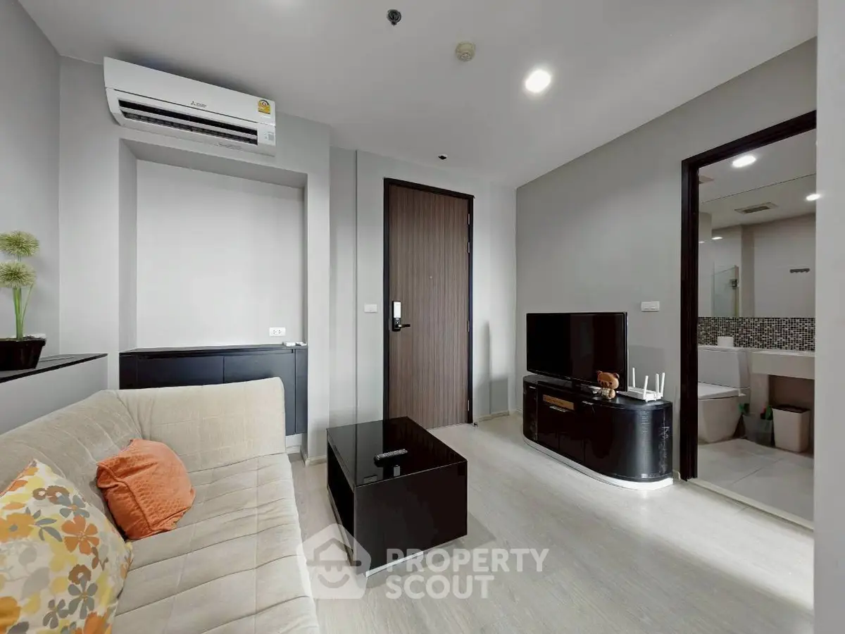 Modern living room with sleek furniture and open bathroom view, perfect for urban living.