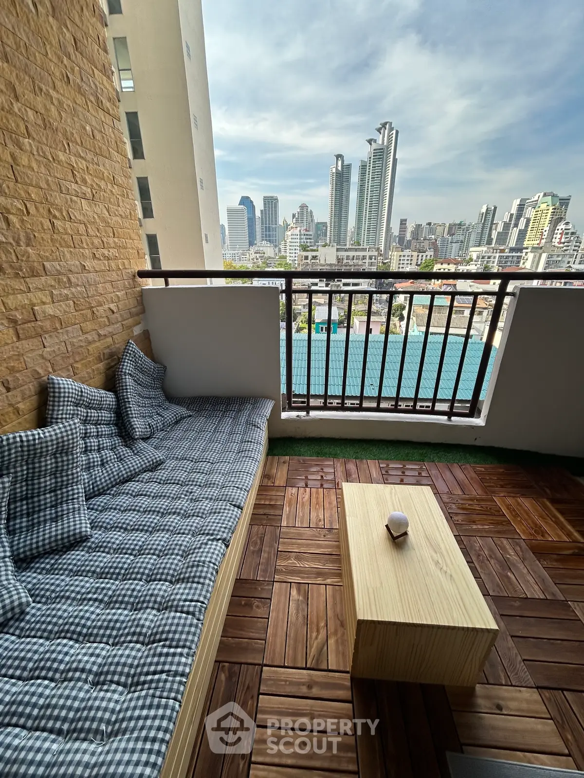 Charming balcony with city skyline view and cozy seating area.