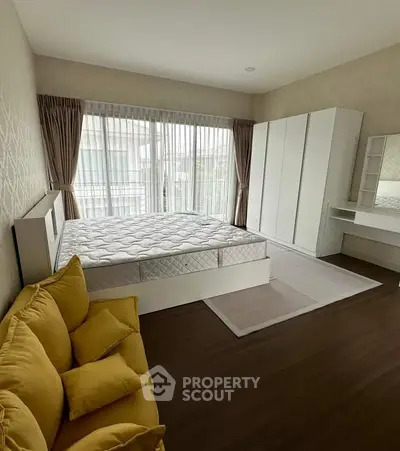 Spacious bedroom with modern decor and large windows for natural light.