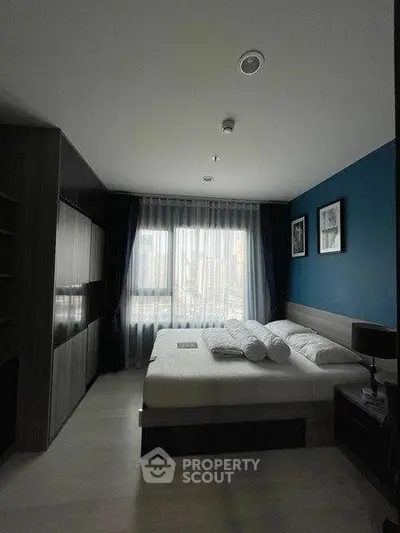 Modern bedroom with city view, featuring sleek design and ample natural light.