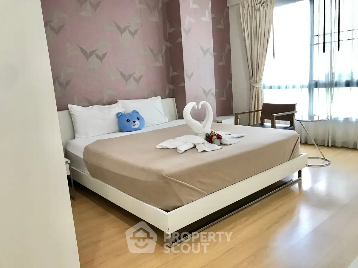 Charming bedroom with stylish decor and natural light, featuring a cozy bed and elegant furnishings.