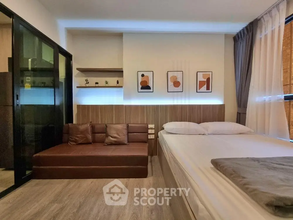 Modern bedroom with stylish decor and cozy seating area, perfect for urban living.