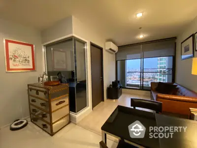 Modern living room with city view, featuring stylish furniture and large windows for natural light.