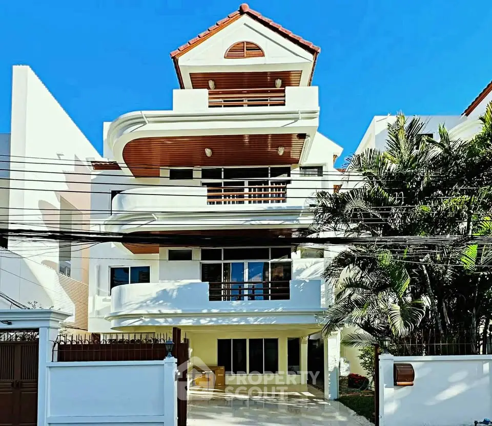 Stunning multi-story modern house with unique architectural design and lush greenery, perfect for luxurious living.