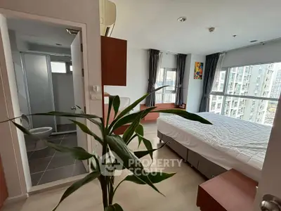 Modern bedroom with ensuite bathroom and large windows in urban apartment