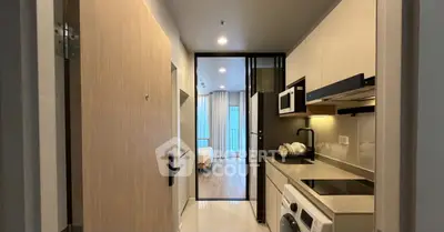 Modern apartment entrance with sleek kitchen and view into cozy bedroom