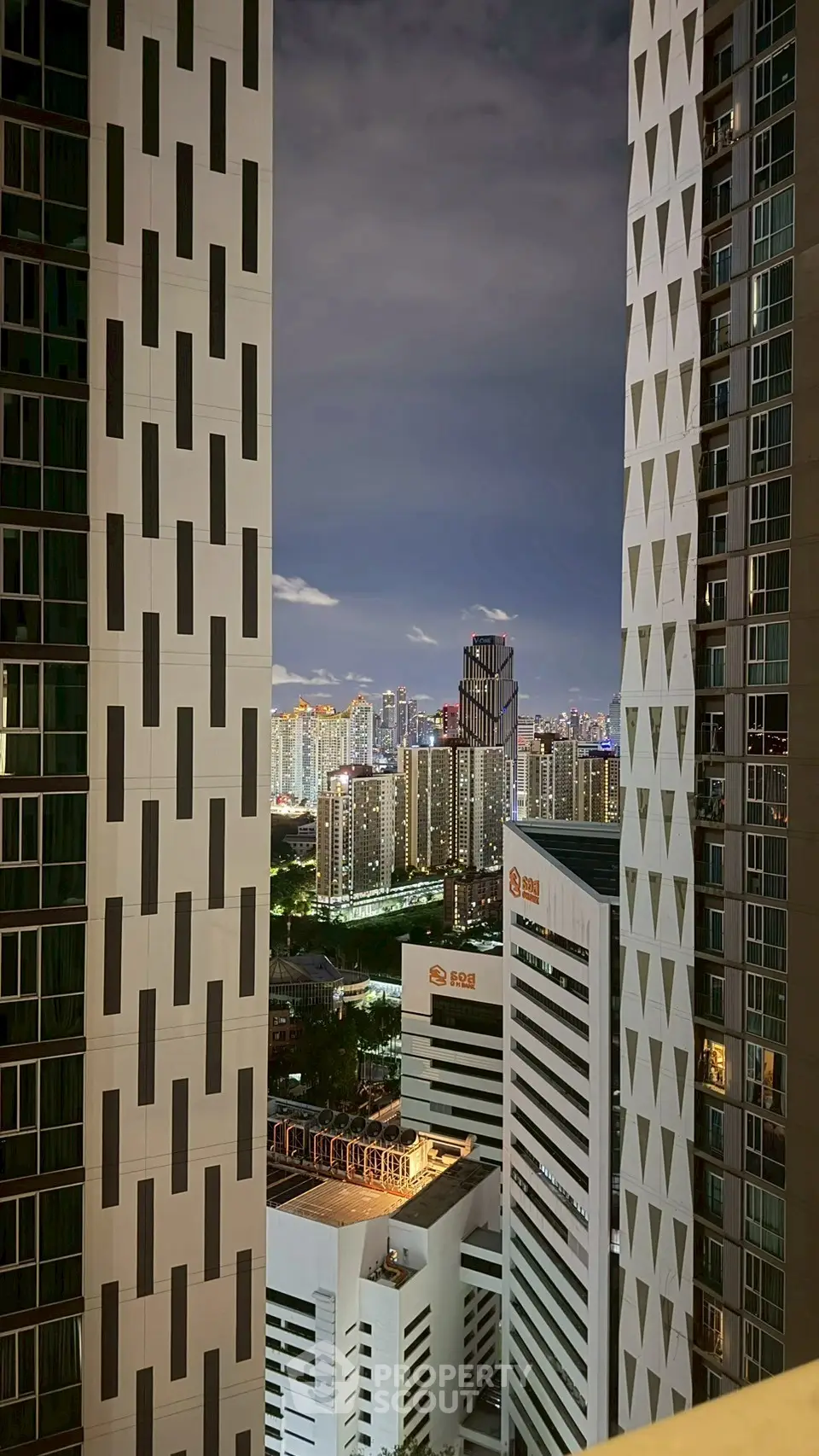 Stunning cityscape view between modern high-rise buildings at night, showcasing urban living.