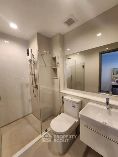 Modern bathroom with glass shower and sleek fixtures in a contemporary home.