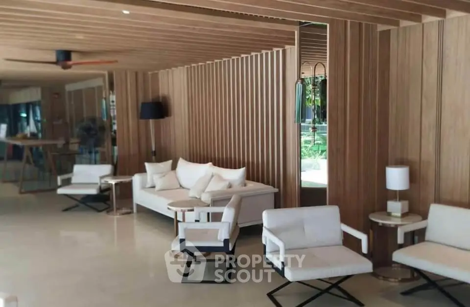 Luxurious modern living room with elegant wooden paneling and stylish white furniture.