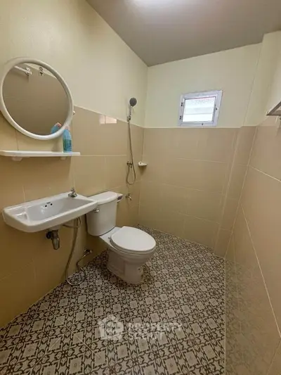 Compact bathroom with modern fixtures and stylish patterned floor tiles.
